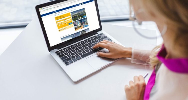 cropped view of woman using laptop with booking website