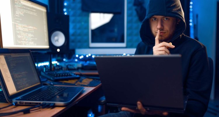 Hacker in hood shows thumbs up, network criminal