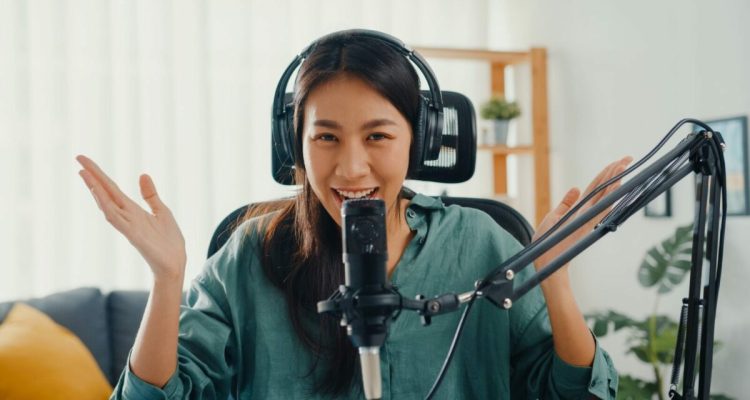 Happy asia girl record a podcast with headphones and microphone look at camera talk and take.