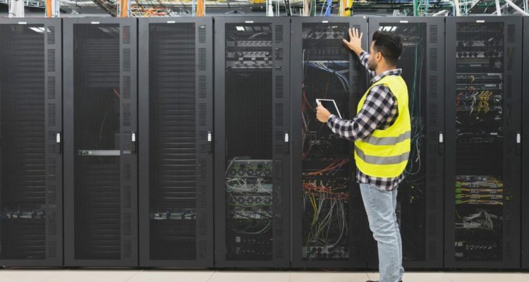 Male informatic engineer working inside server room database